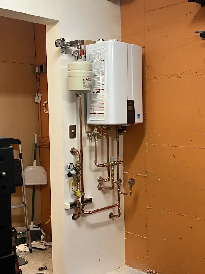 Plumbing technician inspecting water heater connections in Bruce